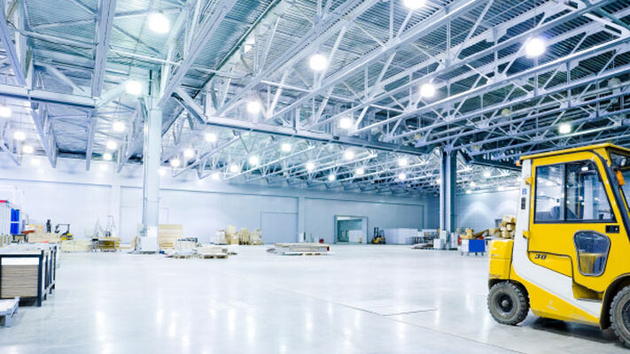 Image of inside of a warehouse with a fork lift all lit with LED lighting